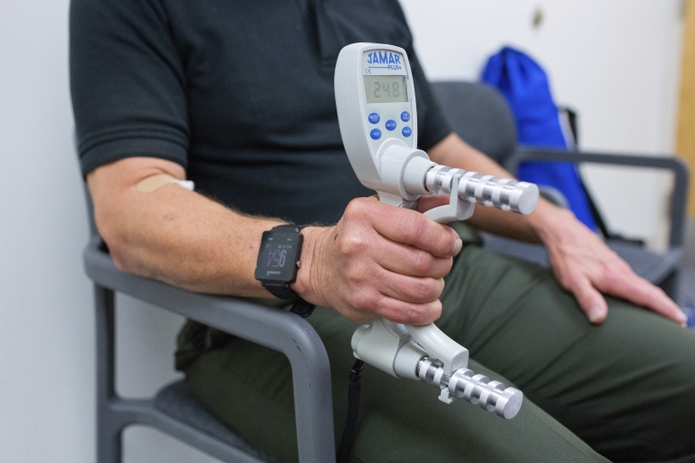 Study volunteer uses device to measure grip strength