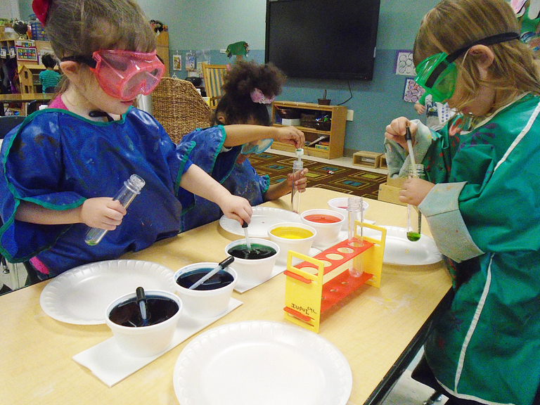 Children with goggles on experiment with paint at the Center for Young Children