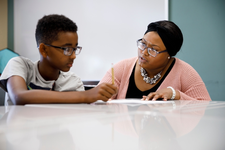 Chiara Logan helps a student with his worksheet