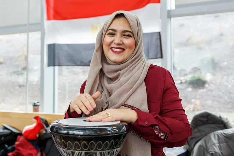 A student wearing a hijab, playing a drum at the International Festival