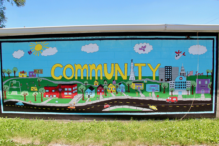 A mural displays 'community' in the Near West.