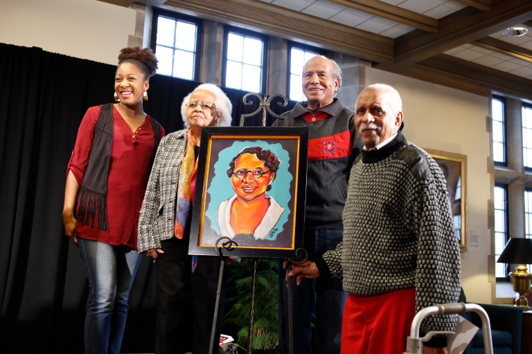 The artist and member's of Carrie Parker Taylor's family stand around the portrait at the event.
