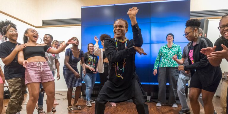 Vodou priest dances in the center of a circle of people clapping