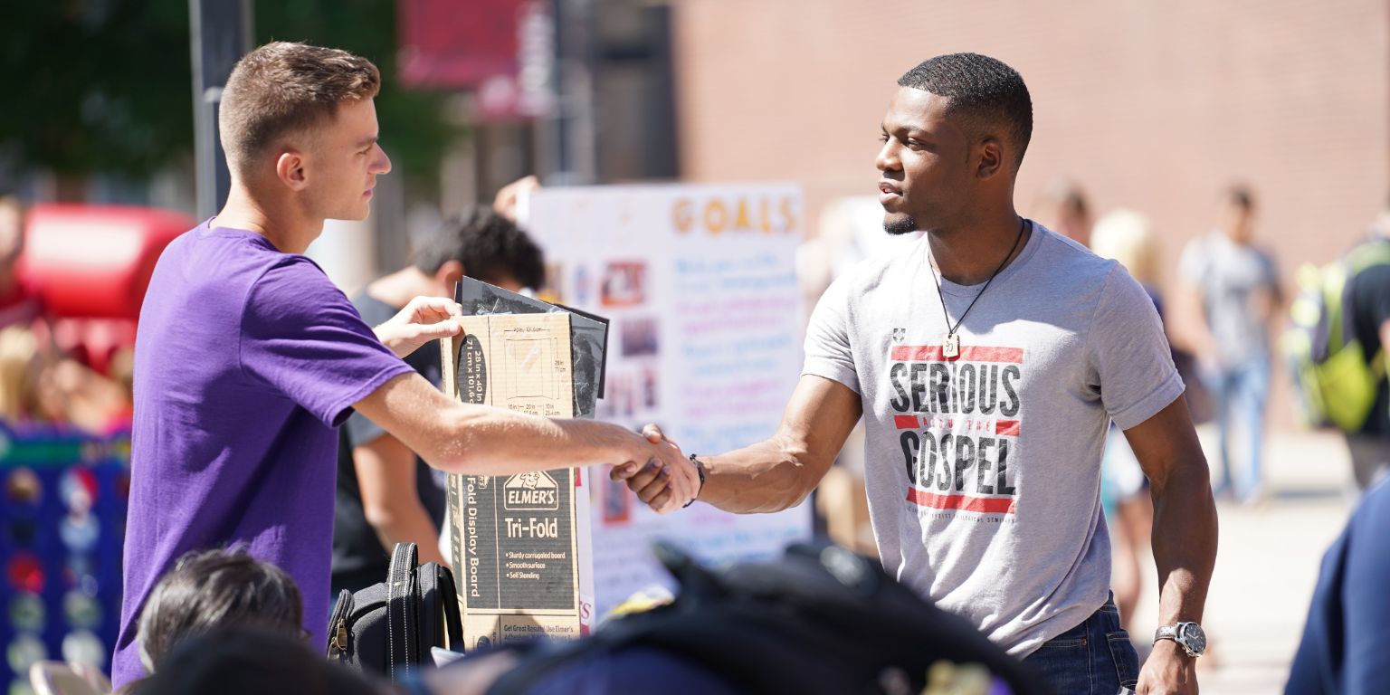 Two male students shake hands at IUPUC