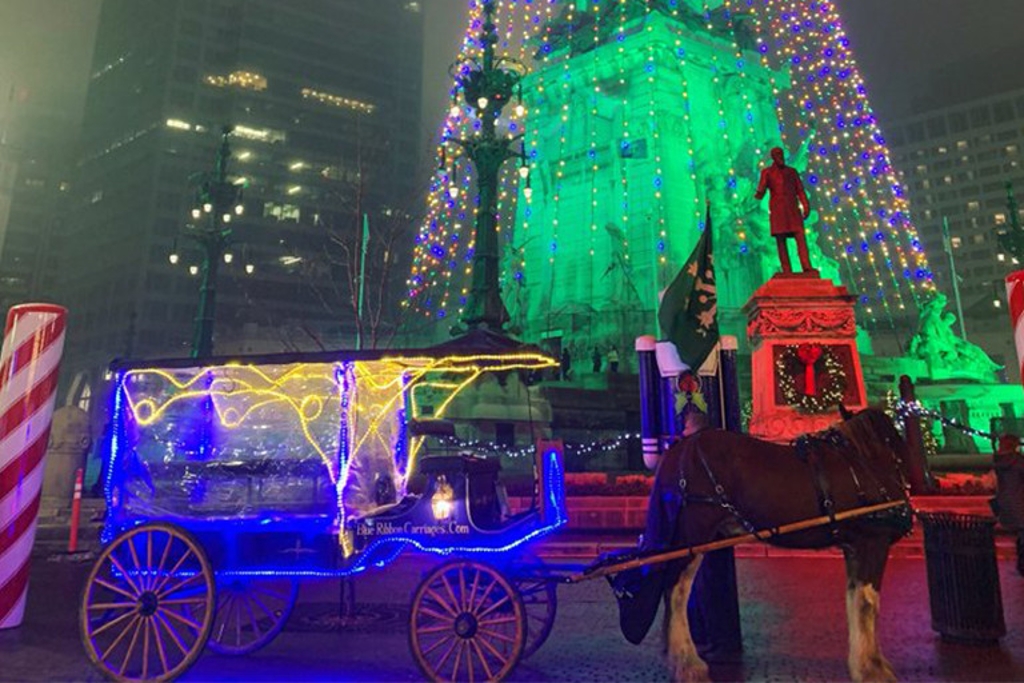 Lit-up horse and carriage ride and the bottom of the tree lights on Monument Circle in Indianapolis.