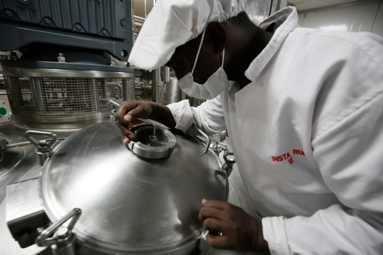 A Kenyan worker checks the mixing tank on the production line.