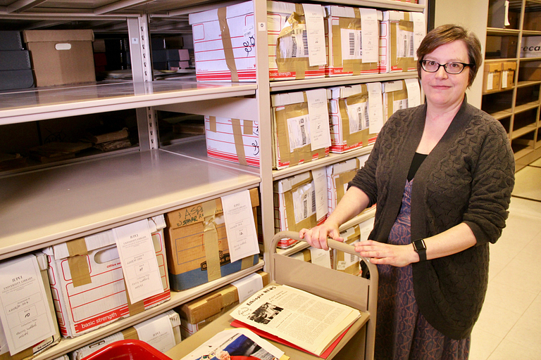 Angela White poses with boxes in the IUPUI archives