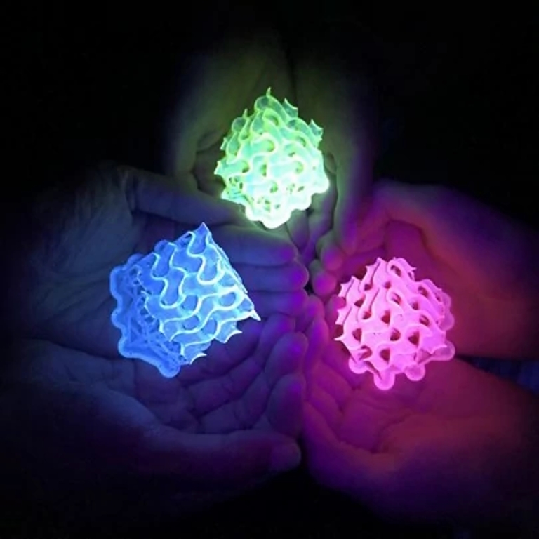 Blue, green and pink 3D-printed gyroids made with SMILES materials fluoresce under UV light