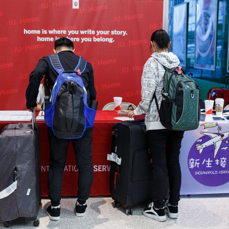 Students standing at a table with their luggage