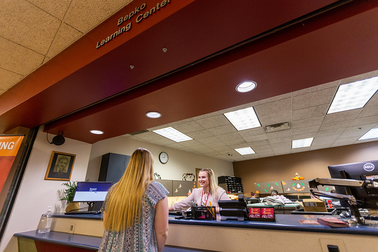 Students greet each other at the front desk of the Bepko Learning Center 