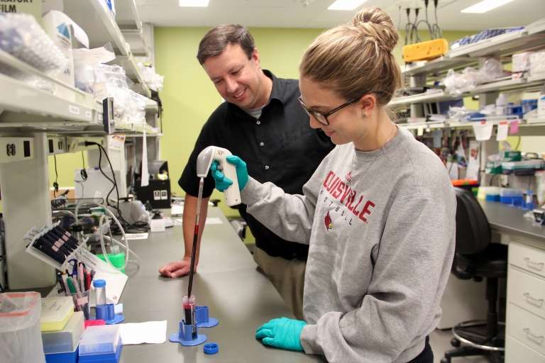 Jason Meyer observes student work in his lab.