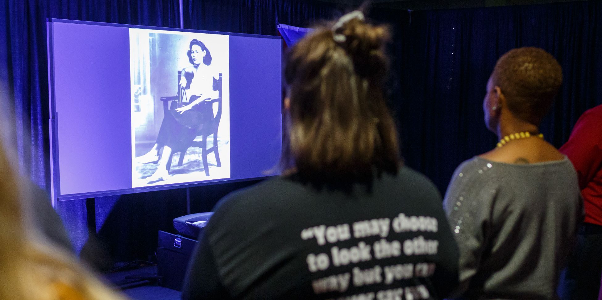 Students watch a multimedia video about the story of a woman who faced oppression in Puerto Rico.
