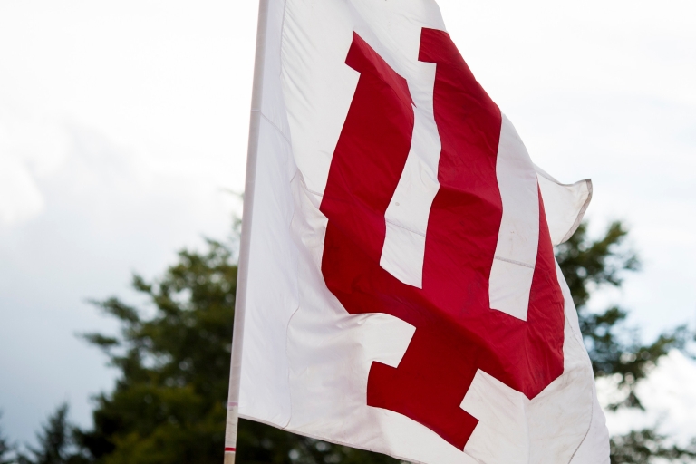 A red and white IU flag flies in the breeze.