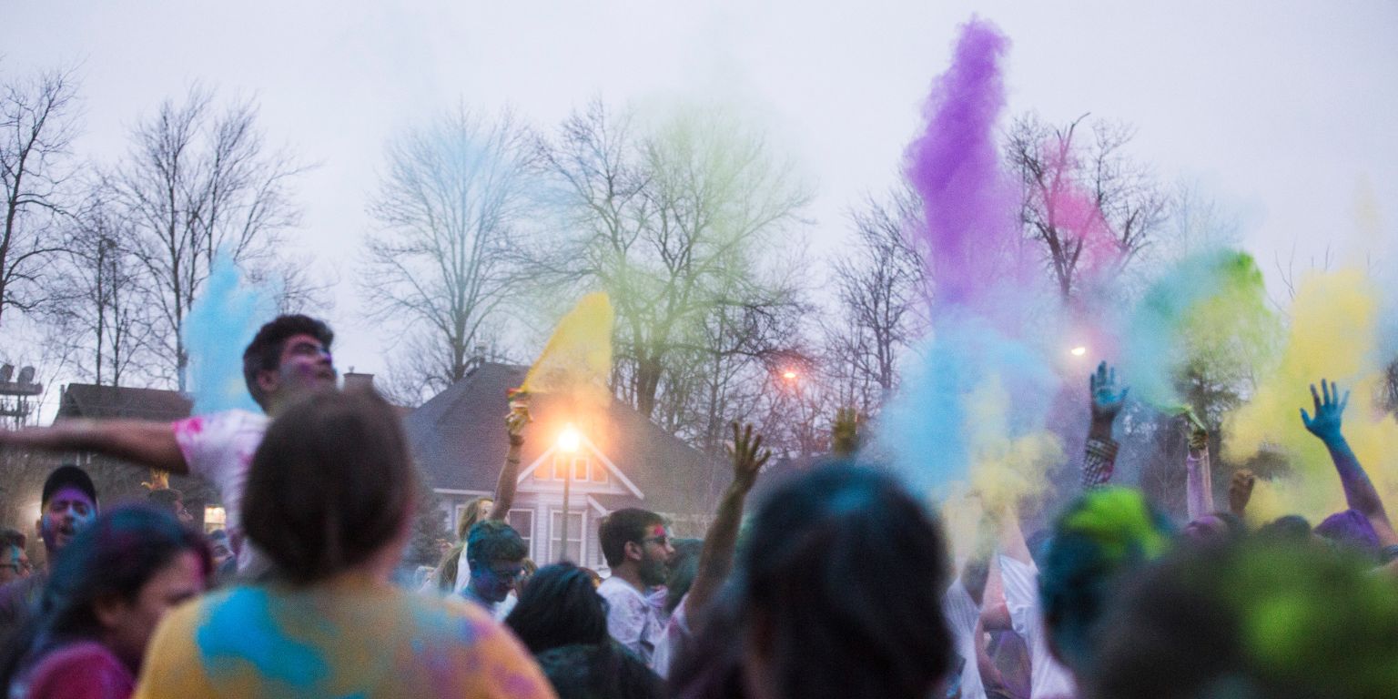 Students toss colored powder in Dunn Meadow