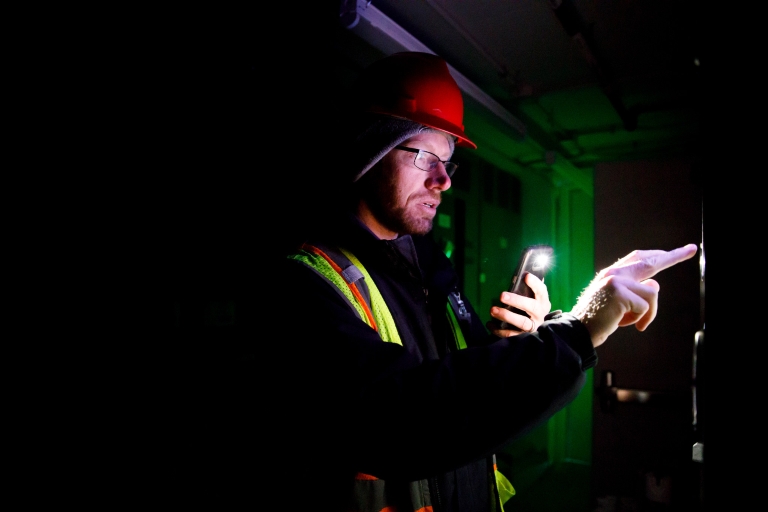 IU Bloomington Meter Data Analyst Ian Yarbrough reads a meter in the basement of Luddy Hall