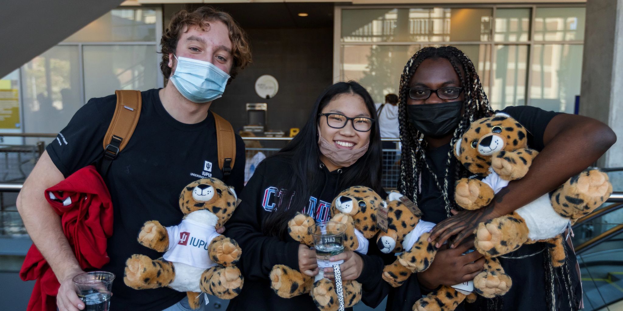 Students holding stuffed jaguars