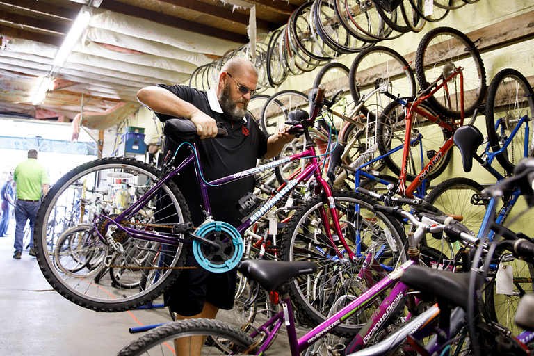 Todd Reid unloads a donated bicycle from a truck