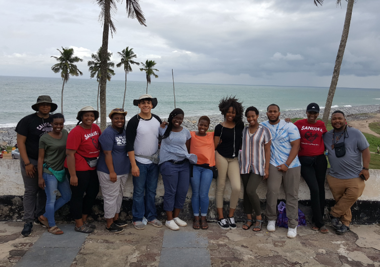 A group of people stand on a beach.