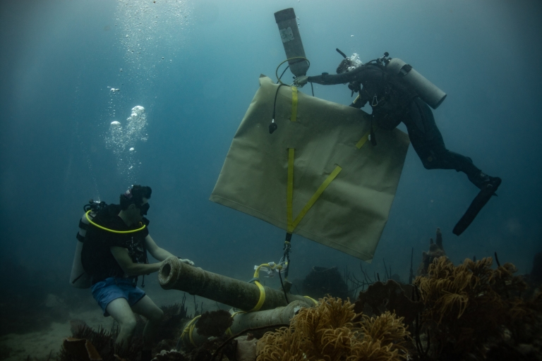 Divers position cannons in underwater museum