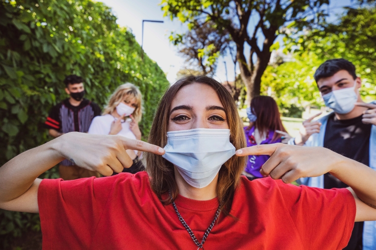 a group of people outside wearing masks and looking at the camera