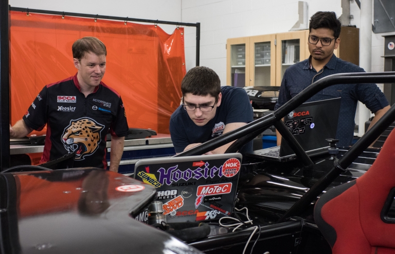 Tyler Stover works on a race car with his students.