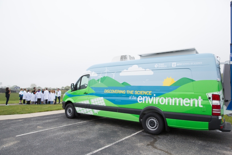 The 'Discovering the Science of the Environment' mobile lab sits in a parking lot.