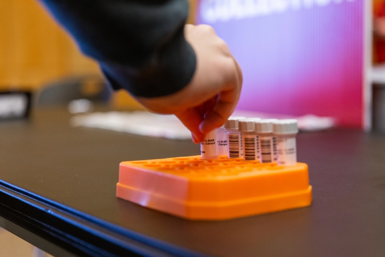 a hand placing a mitigation test into the container