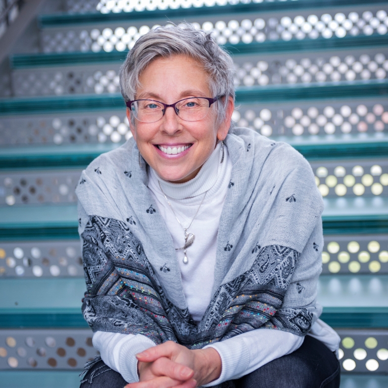 Hilary Kahn sitting on some bleachers and smiling