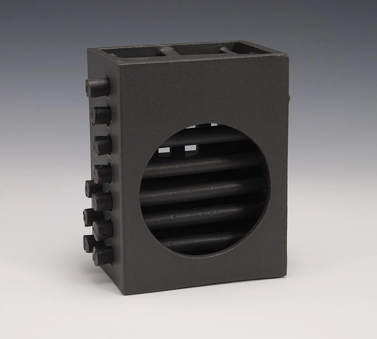 Artwork that is black glazed stonewear, a box with a circular window and rods.