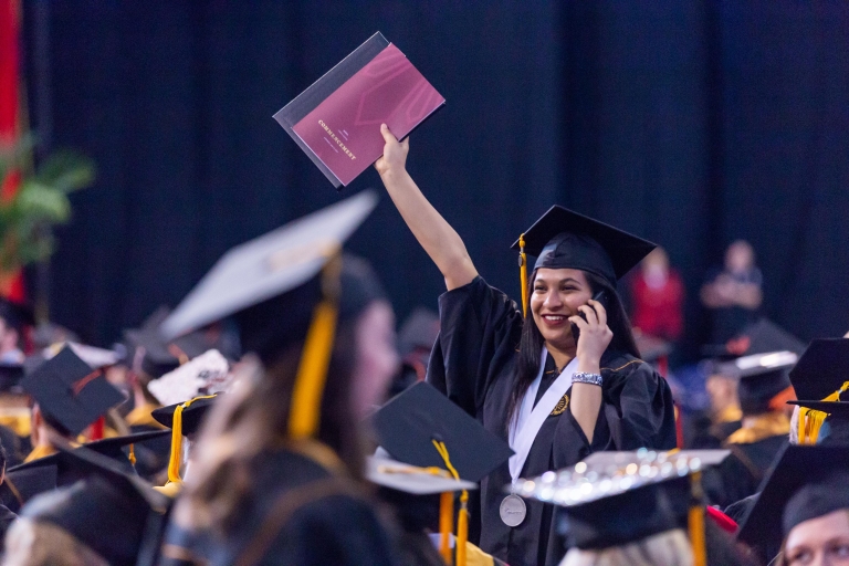 A girl holding up a commencement program at the 2018 IUPUI ceremony