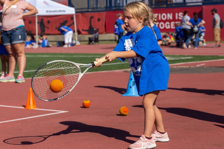 Kid swings a tennis racquet