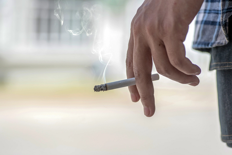 Person's hand smoking a cigarette.