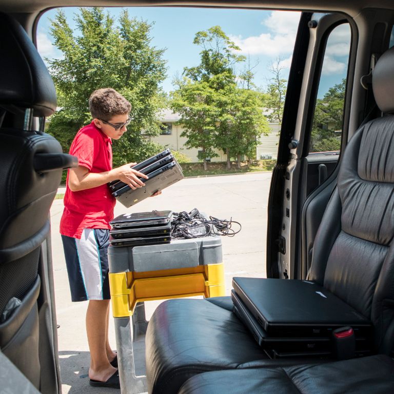Toby Thomassen loads laptops into his mom's van.