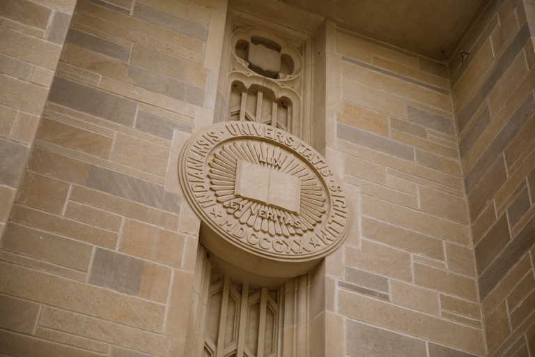 The Indiana University seal on the exterior of a building.