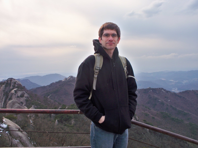 IUPUI graduate student Matthew Greenwood stands at a mountain overlook.