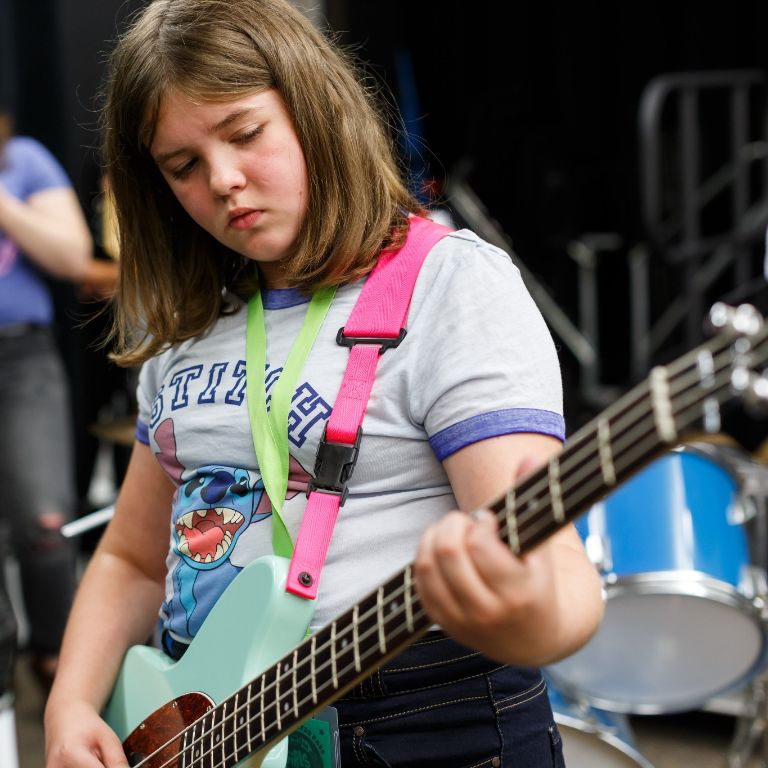 A girl plays bass at Girls Rock! camp.