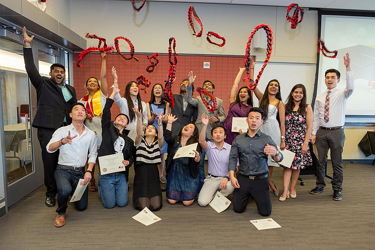 A group of students celebrate at a graduation ceremony.