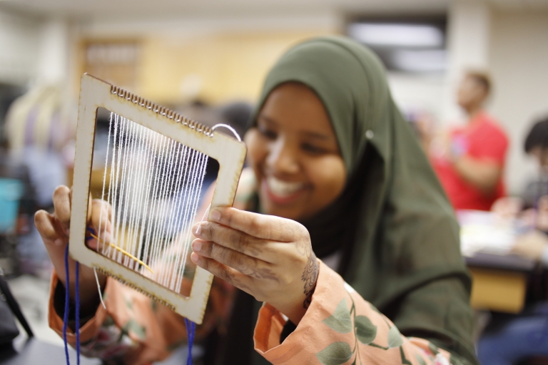 A high school sophomore works on a math weaving activity