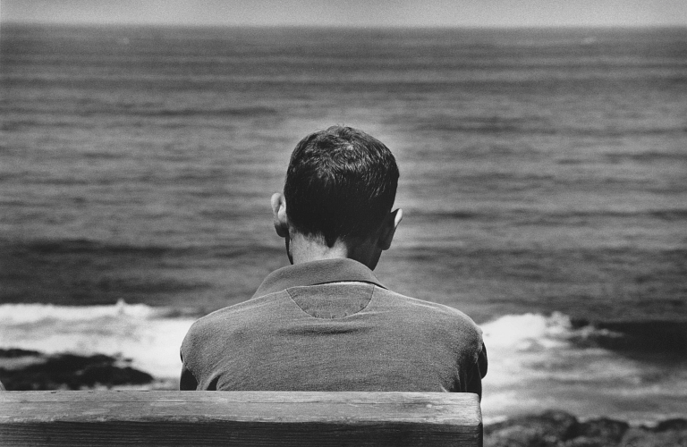 Man sits in front of ocean