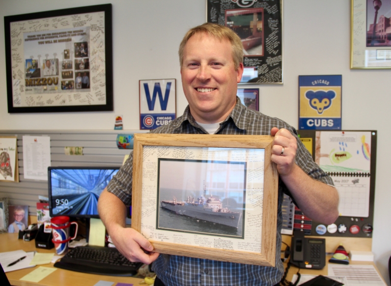 Joe Hayes holds a picture of the USS Portland.