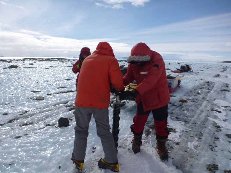 Team members take ice core sample