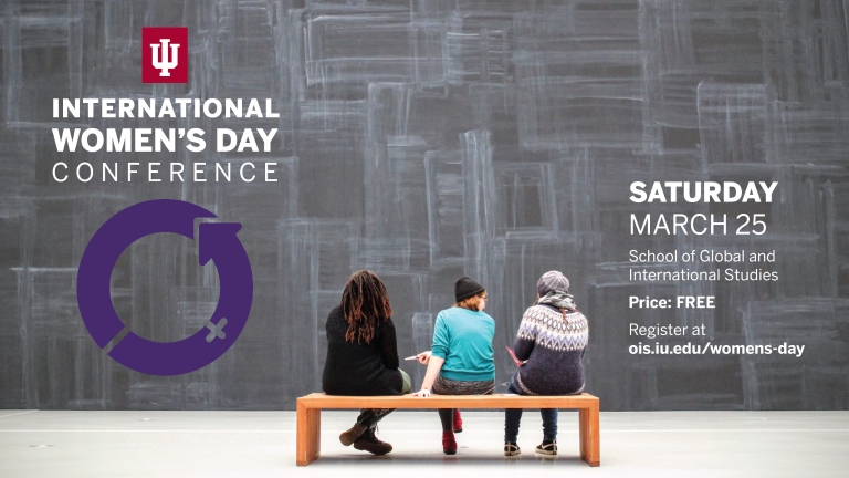 Three women sit on a bench in front of a chalkboard and international women's day conference.