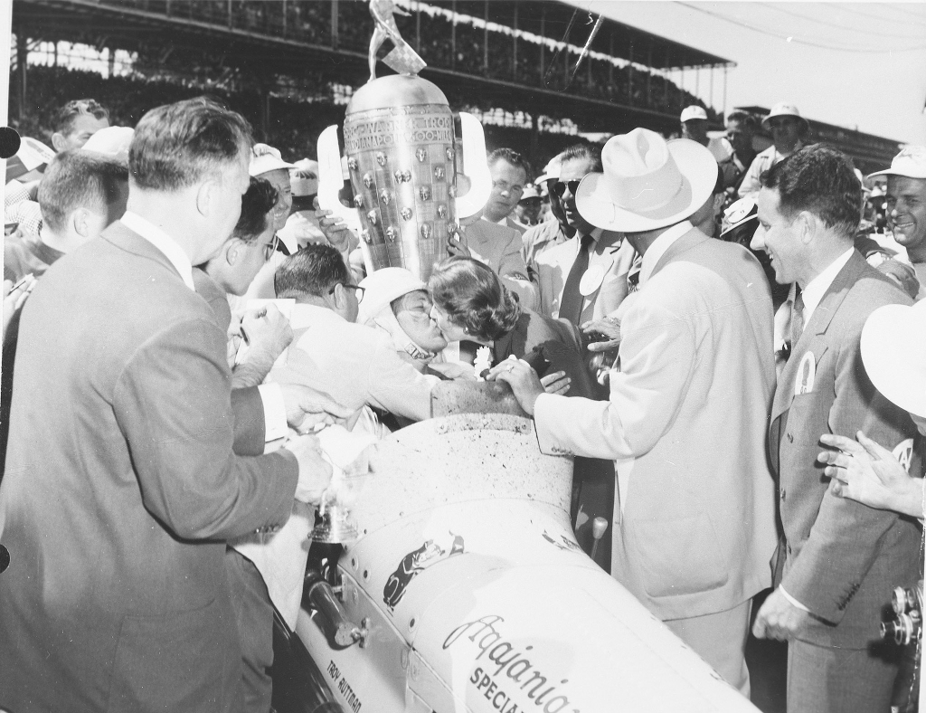 Troy Ruttman receives a kiss as a crowd happily surrounds him in Victory Lane