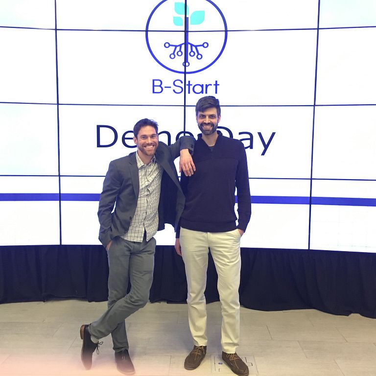 Co-founders of BotMaven stand in front of a screen that says B-Start Demo Day.