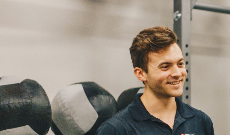 A personal trainer assists a client with a workout