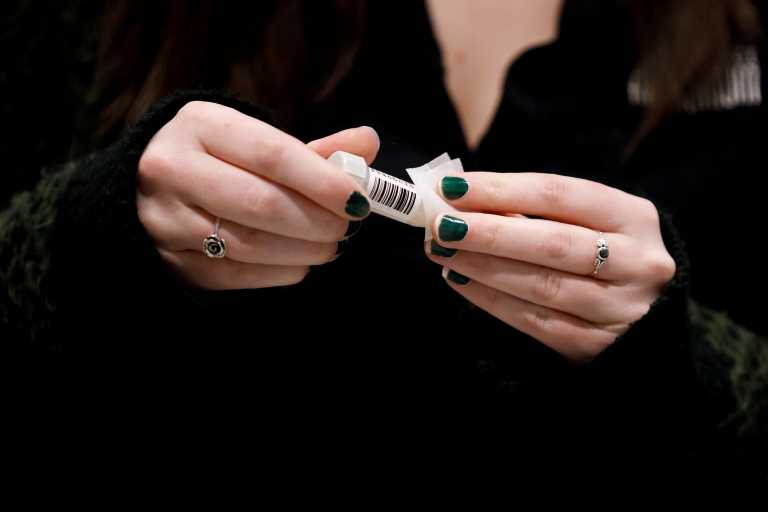 a woman's hands holding a mitigation testing vial