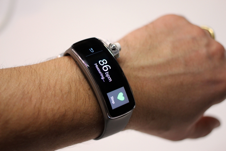A person's wrist wearing a Fitbit showing data