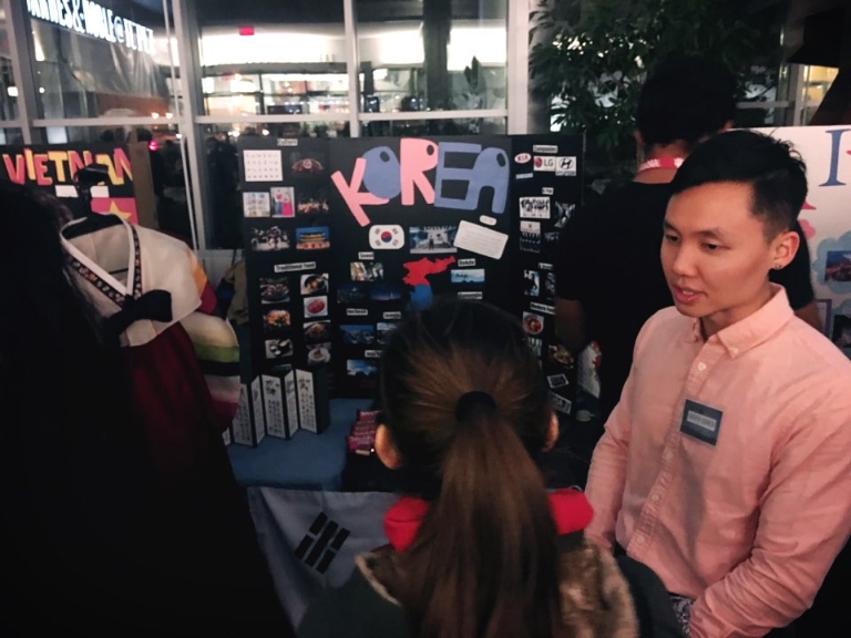 Students speak at a poster presentation.