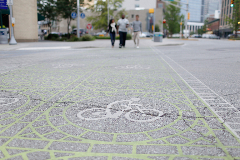 Three people walk across a crosswalk