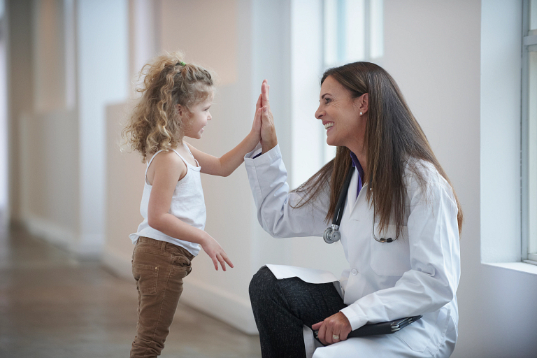 pediatrician high-fives child patient